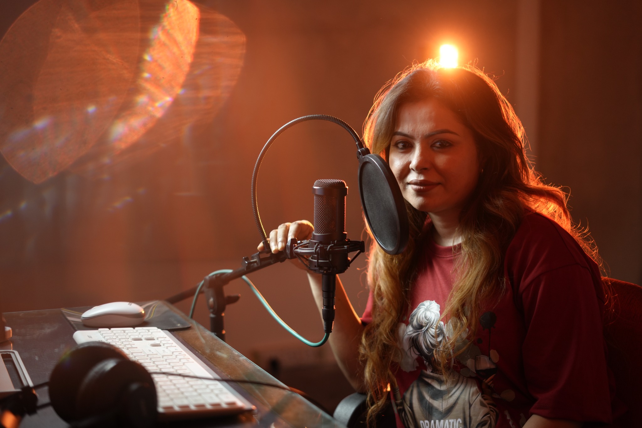Singer beside a microphone and pop filter in a warmly lit recording studio